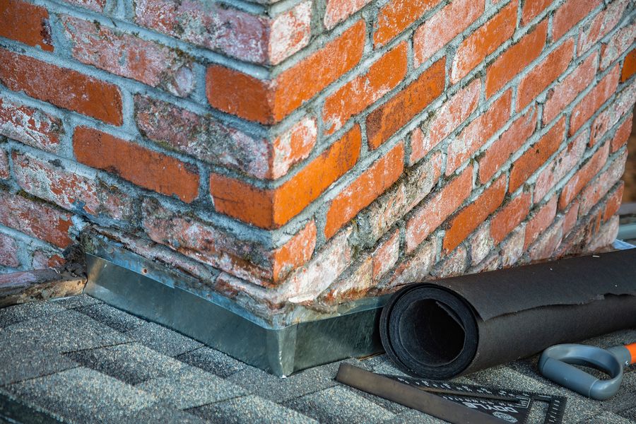 Solin en plomb au pied d'une cheminée en brique